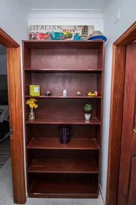 a wooden book shelf in a room at Charming Private Rooms in an Apartment A1 Penha - Faro in Faro