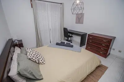 a bedroom with a bed with a desk and a television at Charming Private Rooms in an Apartment A1 Penha - Faro in Faro