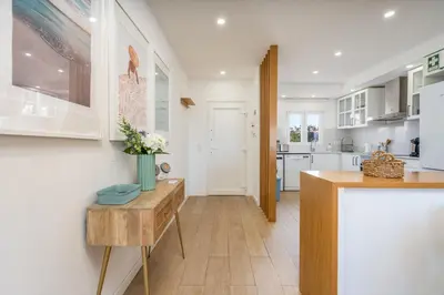 a kitchen with white cabinets and a wooden table at Beco do Sol, Albufeira in Albufeira