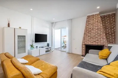 a living room with two couches and a fireplace at Beco do Sol, Albufeira in Albufeira