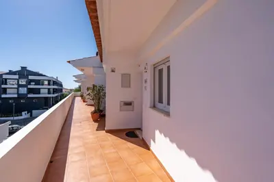 a balcony of a white building with a window at Beco do Sol, Albufeira in Albufeira