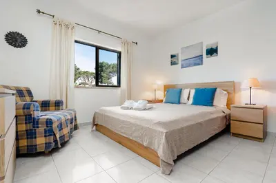 a bedroom with a bed and a chair at Mouramar One bedroom apartment, with pool in Quarteira