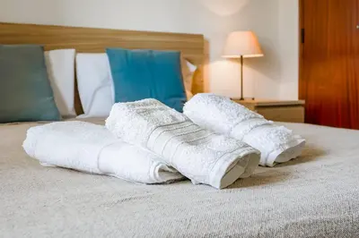 a pile of towels on top of a bed at Mouramar One bedroom apartment, with pool in Quarteira