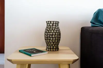 a black and white vase on a table with a book at Mouramar One bedroom apartment, with pool in Quarteira