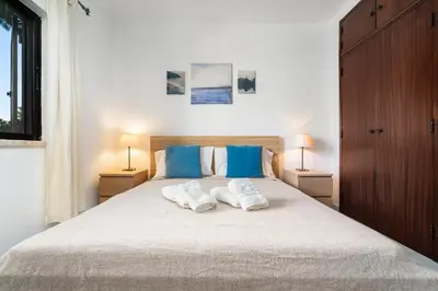 a bedroom with a large bed with two towels on it at Mouramar One bedroom apartment, with pool in Quarteira