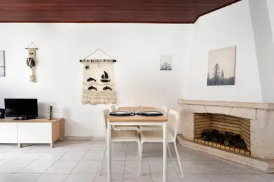 a dining room with a table and a fireplace at Mouramar One bedroom apartment, with pool in Quarteira