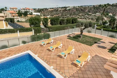 a view of a pool with lounge chairs and a swimming pool at Villa Das Oliveiras amazing location walk to Marina restaurants beach in Albufeira