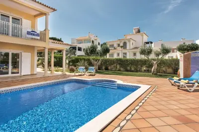 a villa with a swimming pool and a house at Villa Das Oliveiras amazing location walk to Marina restaurants beach in Albufeira