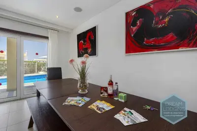 a dining room with a table and a painting on the wall at Villa Rafaella 3 - Dream Lodging in Albufeira