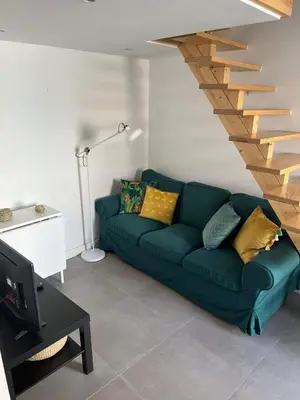 a living room with a green couch and a staircase at CASA DAS MOURAS in Faro