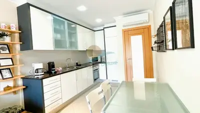a kitchen with a glass table and white cabinets at Garden Residence Premium by Sunny Deluxe in Albufeira