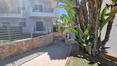 a sidewalk next to a building with a palm tree at Garden Residence Premium by Sunny Deluxe in Albufeira