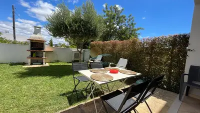 a backyard with a table and chairs and a grill at Garden Residence Premium by Sunny Deluxe in Albufeira
