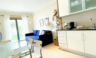 a kitchen and living room with a blue couch at Garden Residence Premium by Sunny Deluxe in Albufeira