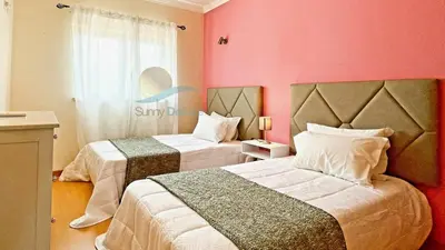two beds in a room with pink walls at Garden Residence Premium by Sunny Deluxe in Albufeira