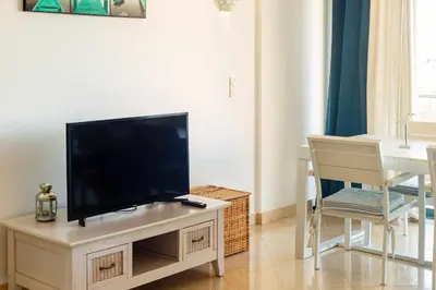 a living room with a flat screen tv on a table at Marina Vilamoura Aquamar 304 By Vilamoura Sun in Vilamoura