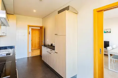 a kitchen with a refrigerator and a table at Marina Vilamoura Aquamar 304 By Vilamoura Sun in Vilamoura