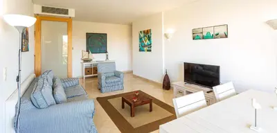 a living room with a blue couch and a tv at Marina Vilamoura Aquamar 304 By Vilamoura Sun in Vilamoura