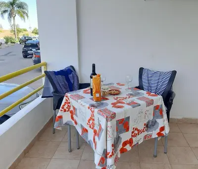 a table with a bottle of wine on top of a balcony at Apartamento Manelito House by Sunyway in Albufeira