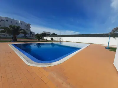 a large blue swimming pool on a brick patio at Apartamento Manelito House by Sunyway in Albufeira