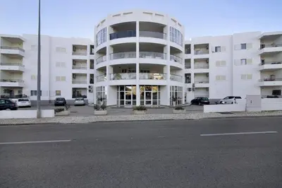 a large white apartment building with a parking lot at Apartamento Manelito House by Sunyway in Albufeira