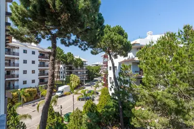 an apartment complex with trees in the foreground at Golden Blue Beach Falésia Apartment in Albufeira