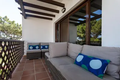 a couch on the balcony of a house at Golden Blue Beach Falésia Apartment in Albufeira