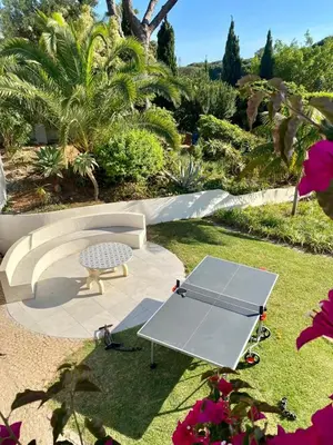 a picnic table and a bench in a garden at Royal Course Villa, Vale do Lobo in Vale do Lobo