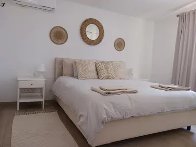 a white bedroom with a bed with two towels on it at Royal Course Villa, Vale do Lobo in Vale do Lobo