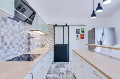 a kitchen with white cabinets and a blue door at Villa Rimbaud in Albufeira