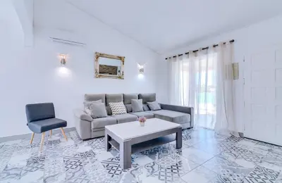 a living room with a couch and a table and a chair at Villa Rimbaud in Albufeira