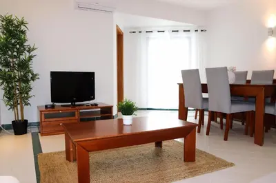 a living room with a table and a television at Apartamento Salgados Mar in Albufeira