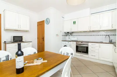 a kitchen with a table with a bottle of wine at Oura Sunrise 3F Apartment by Stay ici Algarve Holiday Rental in Albufeira