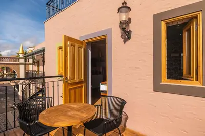 a patio with a table and chairs on a balcony at Vila Origens Boutique Hotel Albufeira – Adults Only in Albufeira
