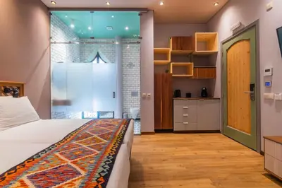 a bedroom with a bed and a kitchen at Vila Origens Boutique Hotel Albufeira – Adults Only in Albufeira