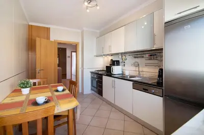 a kitchen with a table and a stove top oven at Quarteira Beach I in Quarteira