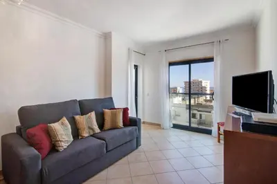 a living room with a couch and a flat screen tv at Quarteira Beach I in Quarteira