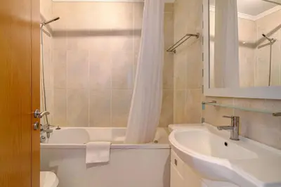 a bathroom with a sink and a tub and a toilet at Quarteira Beach I in Quarteira