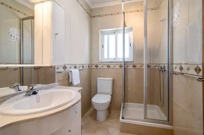 a bathroom with a toilet and a sink and a shower at Quarteira Beach ii in Quarteira