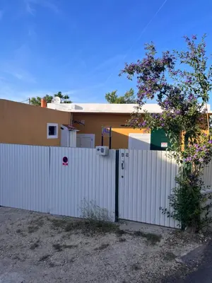 a white fence in front of a house at Casa Amarela in Loulé