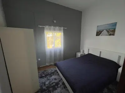 a bedroom with a bed and a window at Casa Amarela in Loulé