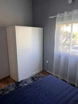 a bedroom with a blue bed and a window at Casa Amarela in Loulé