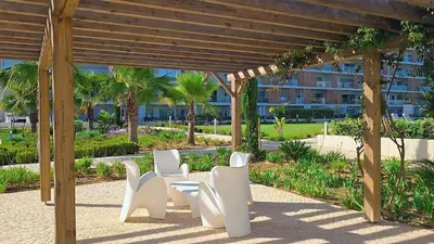 a group of white chairs sitting under a pergola at Marvell Design with heated pool&Playground in Albufeira