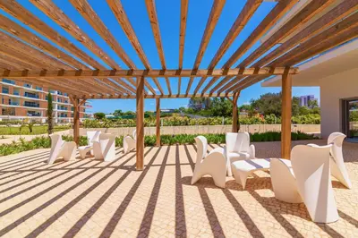 a group of white chairs under a pergola at Marvell Design with heated pool&Playground in Albufeira
