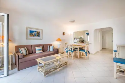 a white villa with a yard with a table and chairs at Albufeira Family Holidays @ Balaia 143 in Albufeira