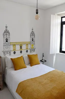 a bedroom with a large bed with yellow pillows at Arty Casa in Faro