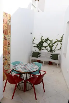 a patio with a table and chairs and a bench at Arty Casa in Faro
