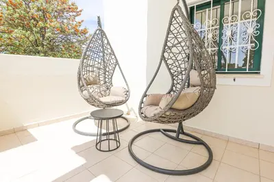 two swing chairs and a stool in front of a window at Villa O Sonho do Algarve - Private Swimming Pool - BY BEDZY in Albufeira