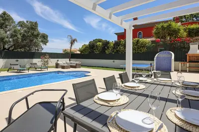 a patio with a table and chairs next to a pool at Villa O Sonho do Algarve - Private Swimming Pool - BY BEDZY in Albufeira