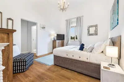 a white bedroom with a bed and a television at Villa Isabella by OCvillas in Paderne